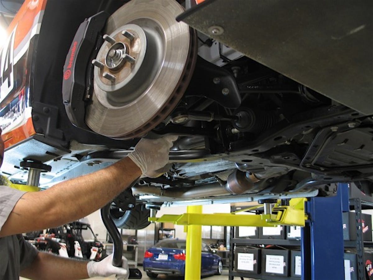Beginning with removing the stock front bar, on the passenger side, it’s easiest to access the mounting hardware from under the hood with a long extension for socket. When the four bolts are removed, and end links are disconnected, the bar is removed from the passenger side of the car.