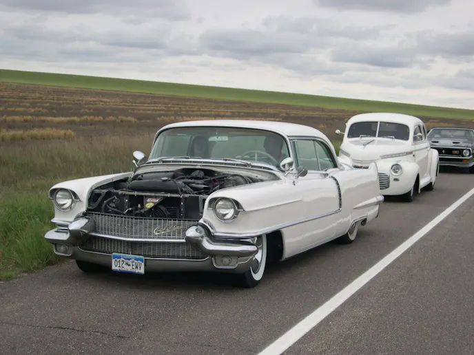The '56 still in its Earl Schieb paint job and after the hood was replaced (and primed in white) and Ford "Cruiser" skirts were made to fit. Lakes Pipes were added.