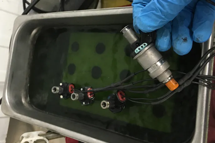 The ultrasonic phase places injectors in a bath of cleaning fluid, while the injectors are connected to a power supply and are pulsed for about an hour. Simultaneously, sound waves help to break off debris from the injectors.