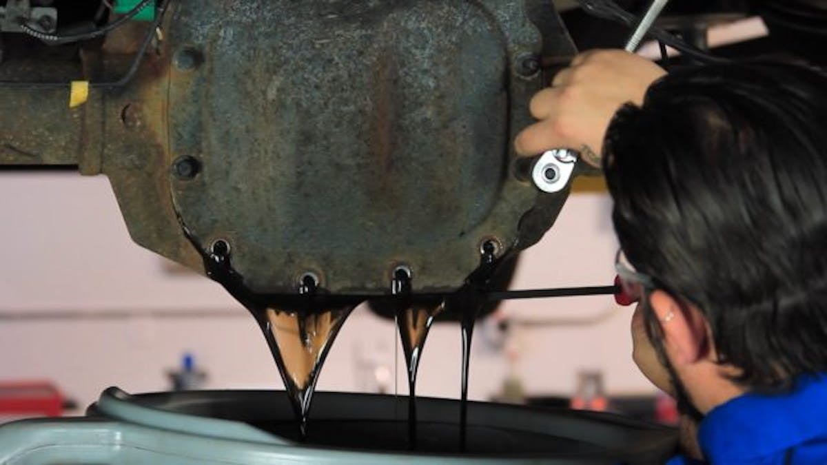 Start by raising the truck, placing a drain pan under the rearend and removing all but the top cover bolt. Then you can pry the factory differential cover free and drain out the fluid. Once the fluid is drained, you can remove the factory cover.