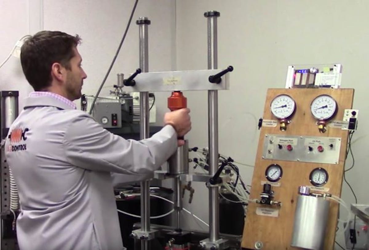 This custom rig is used to fill the damper with oil, pressurize it with inert gas, then seal the whole assembly with a snap ring. Each application gets a different quantity of oil and amount of gas pressure - in this case, a C5 front damper is being filled.