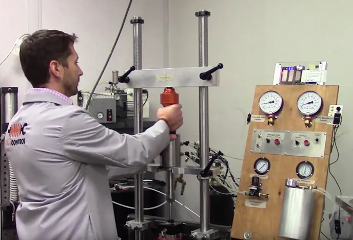 This custom rig is used to fill the damper with oil, pressurize it with inert gas, then seal the whole assembly with a snap ring. Each application gets a different quantity of oil and amount of gas pressure - in this case, a C5 front damper is being filled.