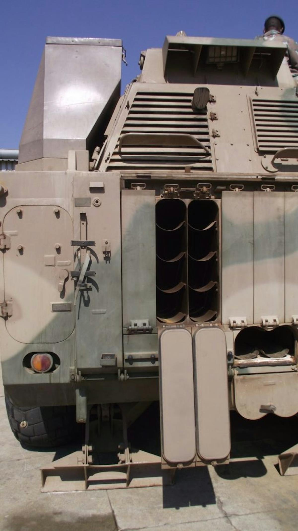 Projectiles, charges, primers and fuses are carried in racks at the rear of the G6's chassis on each side. An access hatch for crew entrance/exit of the turret is on the rear. Additionally, two ammunition hatches, one to each side of the main hatch, offer additional storage of the ammunition supply. On the roof of the turret at the left cupola, a 7.62 or 12.7 millimeter machine gun (typically the latter) can also be equipped. Eight launchers for high explosive and smoke grenades are mounted on the turret, four per side. Image: Tank Encyclopedia