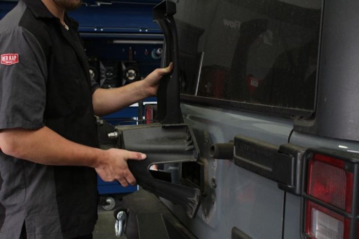 Unbolt the factory tire carrier and set it aside.