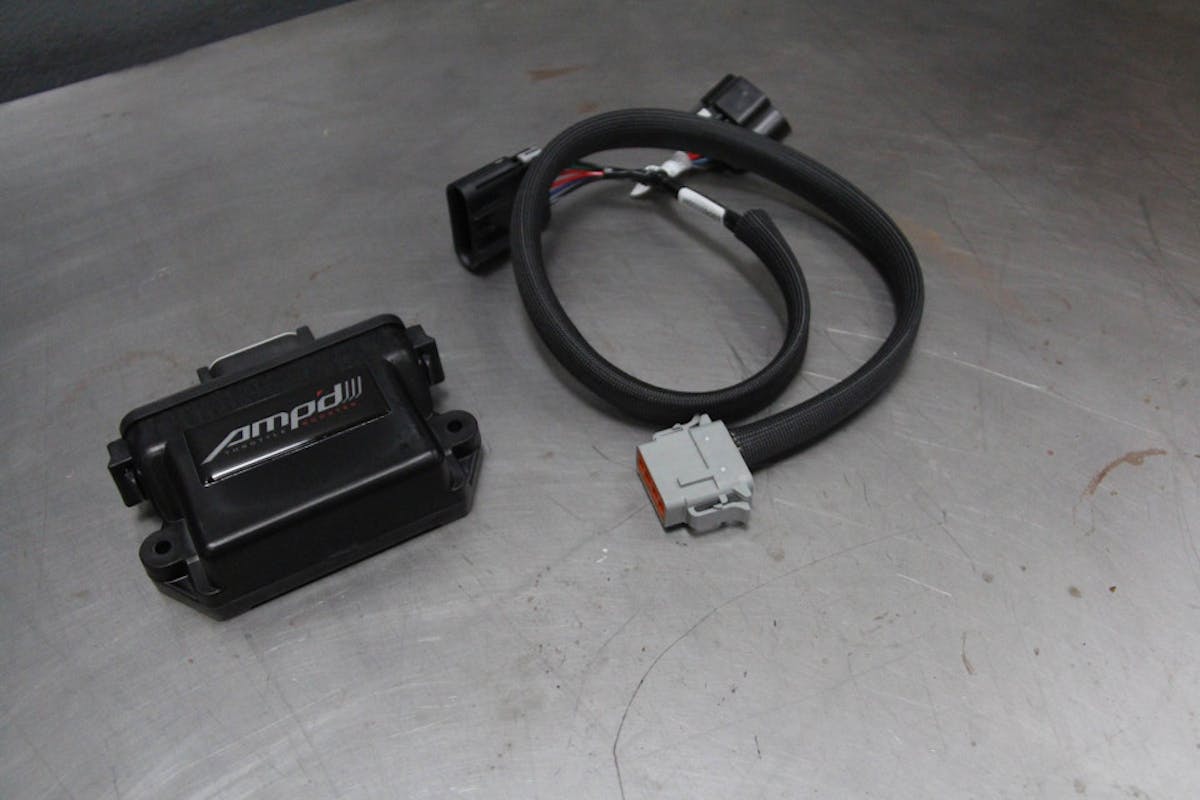 Image of AMP'd throttle booster with harness on bench