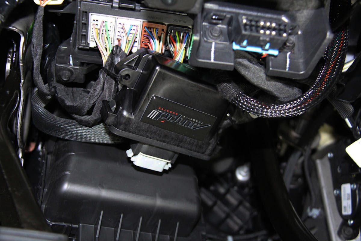 image shows AMP'd Throttle Booster zip tied under the dash