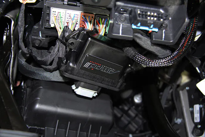 image shows AMP'd Throttle Booster zip tied under the dash