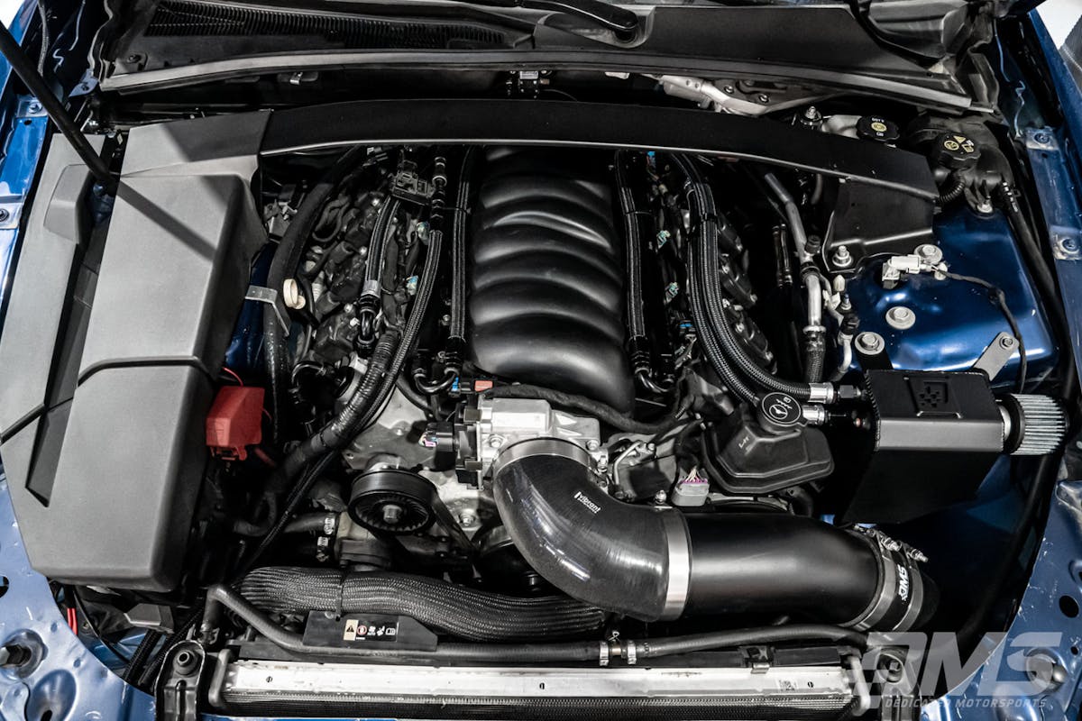 A clean CTS-V Engine bay is shown with the Dedicated Motorsports Catch Can Setup mounted on the drivers side.