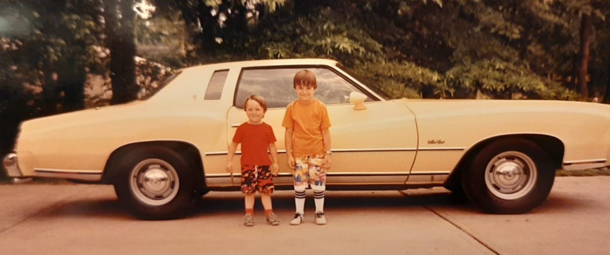 Earnie's 1977 yellow monte carlo pictured with his sons