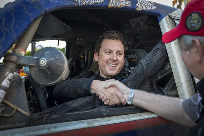 Luke McMillin is congratulated by a SCORE official as he crossed over the finish line.