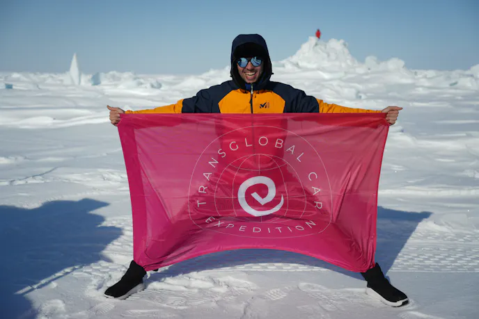 Transglobal Car Expedition holding red glad with their name and logo