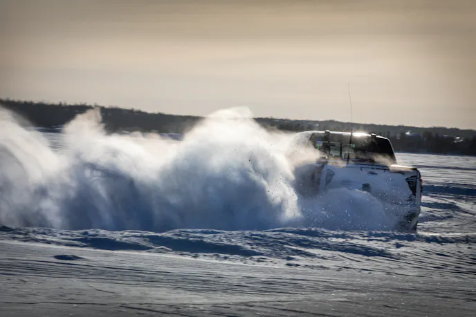 Ford Raptor with huge snow cloud while racing on Great Slave Lake during 2024 Alcan 5000 Rally