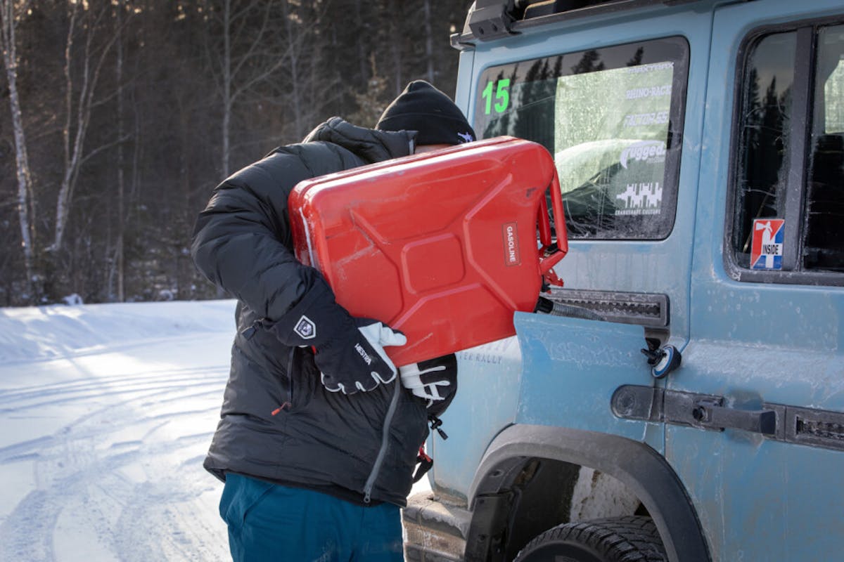 Man filling up SUV with red jerry can during 2024 Alcan 5000 Rally