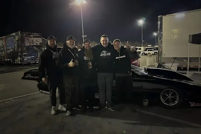 men standing beside a black car