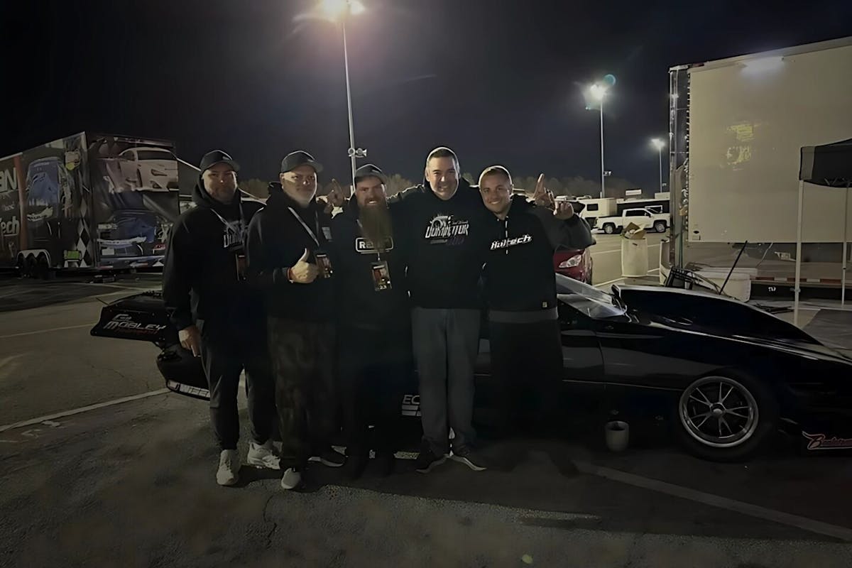 men standing beside a black car