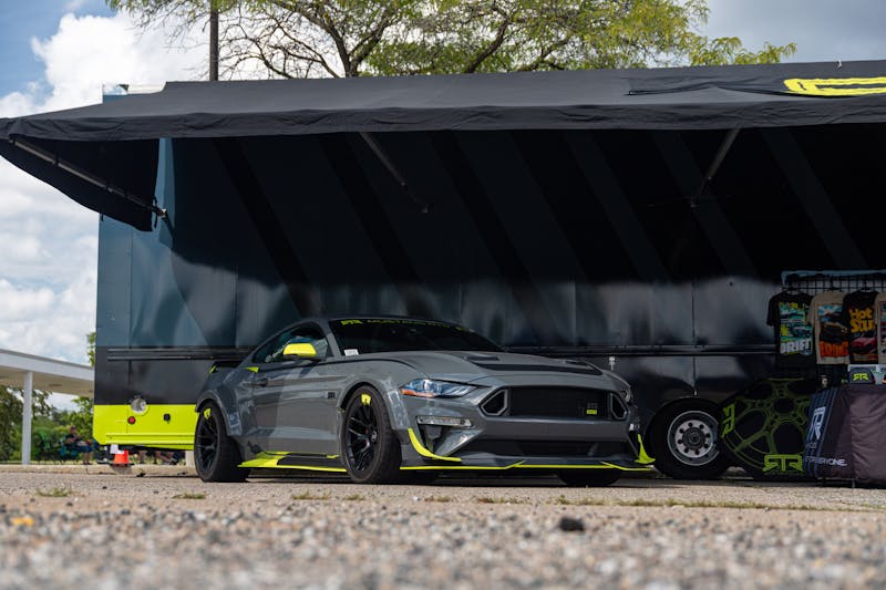 Gray and Yellow Mustang under an awning