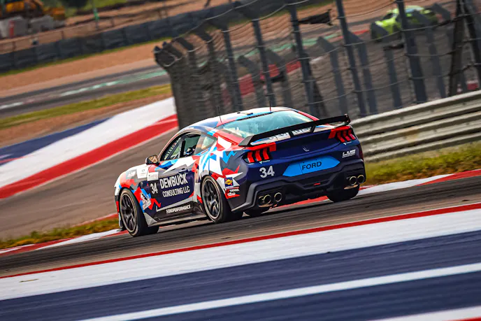 Multi colored Mustang Racing on track