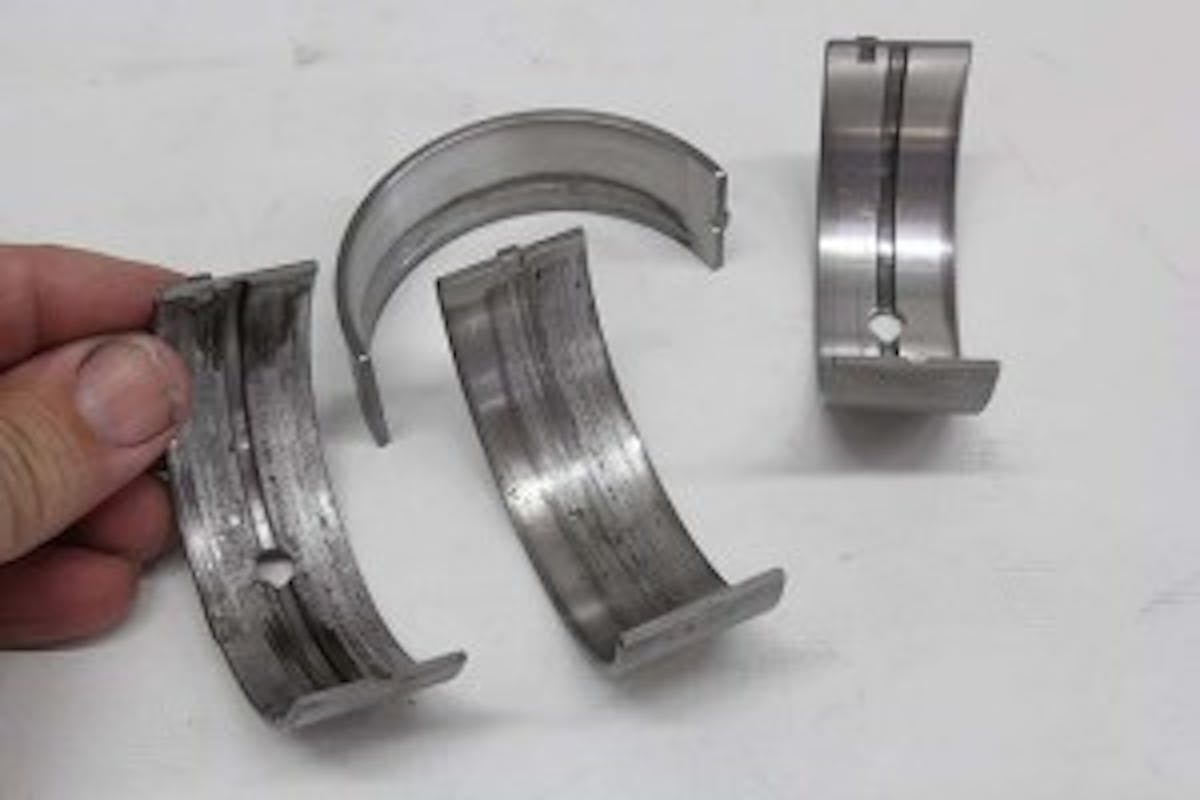 This is the aluminum main bearing we pulled from our big-block Chevy engine when it began to destroy the bearings. Note how a portion of the bearing is severely scratched. This is where the aluminum alloy was pulled away by the crank. That’s the metal we found in the oil. A softer tri-metal bearing would have been worn down but would not have dumped bearing material into the oil – unless it was severely distressed – at which point you have other problems.