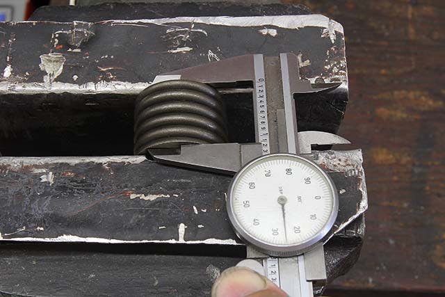 If you have a spring of unknown origin, you can measure coil bind by carefully placing the spring in soft aluminum jaws in your vise, collapsing the spring and measuring the height. Sometimes you may discover your spring binds at a slightly lower number than listed in the catalog. That’s why it pays to measure. Never place a spring in a vise where the jaws can contact the outside of the coils – this can damage the spring.