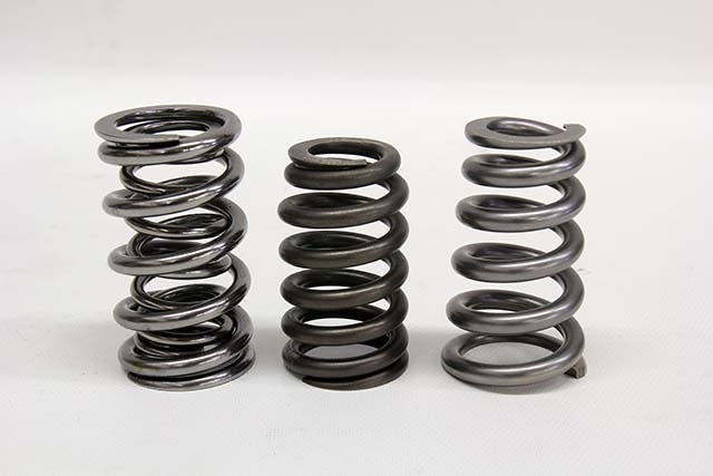 One of the latest innovations in spring design is the conical spring. This is a slight deviation from the beehive with the same advantages. A conical spring uses a gradual reduction in outside diameter over a greater distance than a beehive. This can be viewed as an improvement in strength and durability over a beehive, yet the conical still enjoys the benefits of a variable rate and a smaller retainer vs a conventional spring. In this photo from left to right is a conventional dual spring, a beehive, and a conical spring.