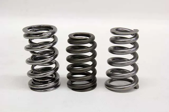 One of the latest innovations in spring design is the conical spring. This is a slight deviation from the beehive with the same advantages. A conical spring uses a gradual reduction in outside diameter over a greater distance than a beehive. This can be viewed as an improvement in strength and durability over a beehive, yet the conical still enjoys the benefits of a variable rate and a smaller retainer vs a conventional spring. In this photo from left to right is a conventional dual spring, a beehive, and a conical spring.