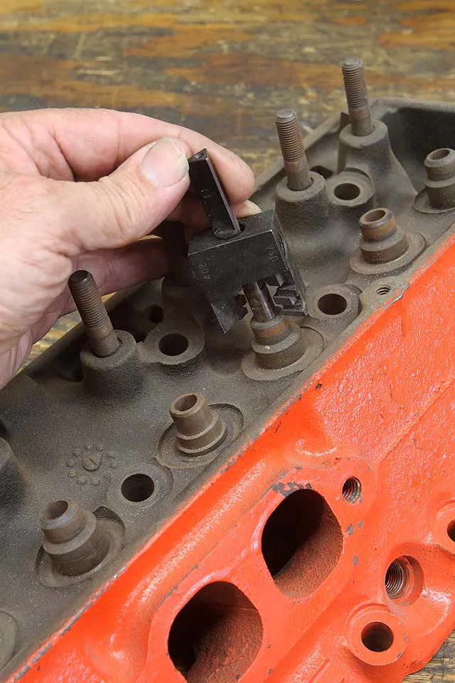 Production cylinder head valve guides are often both too large and too tall. Comp offers arbors and cutters that you can use to reduce both the outside diameter and the height while also cutting the guide for a performance Viton style seal. These tools are especially useful when modifying a production small-block Chevy head. Note that the guide in the foreground has already been cut.