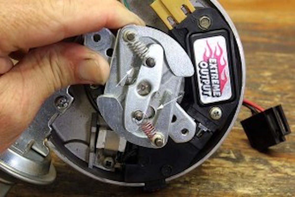 Nearly all distributors use a pin in a slot to determine the amount of mechanical advance allowed. The length of the slot as well as the size of the pin and its bushing limit the amount of advance. This is an HEI distributor, and the arrows indicate the two slots with pins that protrude through the plate. You can lengthen this slot to increase mechanical advance or braze it up to reduce its travel distance to reduce total advance.