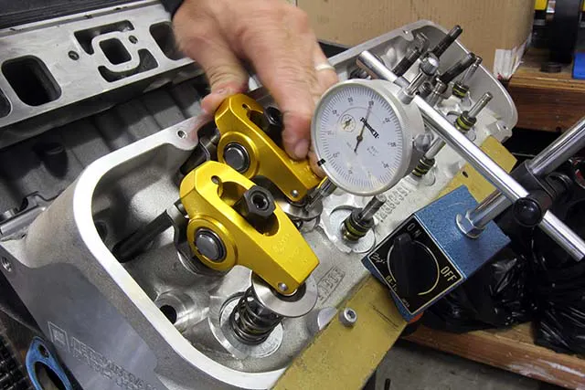 If you do not want to remove the heads, you can still check P to V by using a dial indicator, magnetic base, and checking springs on both valves. Place the indicator plunger on the valve spring retainer (Intake shown here). Rotate the engine to place Number One piston at 10 degrees ATDC. Zero the dial indicator at this valve lift and use the rocker to open the valve until it contacts the piston. The amount of additional lift displayed on the dial indicator is the intake P to V clearance. You may want to rotate the crank 5 degrees on either side of 10 ATDC to find the tightest spot.