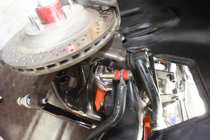 This is the front suspension on our ’65 Chevelle test subject. The upgrades include B-body spindles, Global West tubular upper and lower control arms, 1.125-inch front anti-roll bar, and Global’s extended coil-over shock conversion. The front brakes are an early Baer conversion using C4 calipers and 13-inch rotors. The only missing item is the coil-over shocks that were removed for testing. Also note that we removed the connection for the anti-roll bar for the same reason.