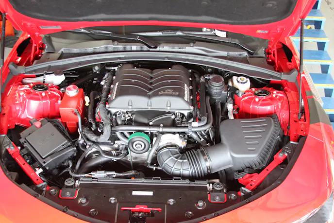 Neatly tucked under hood, this Granatelli-ized installation includes not only the Magnacharger, but his Malevolent 85 KV coil packs and 0 Ohm spark plug wires.