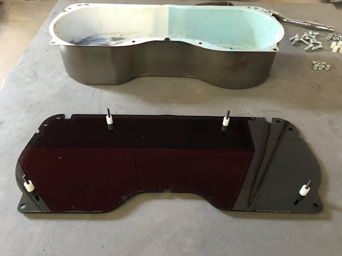 After carefully peeling off the protective covering, the supplied machine screws and spacers pin/stands are installed at the perimeter of the instrument panel lens.