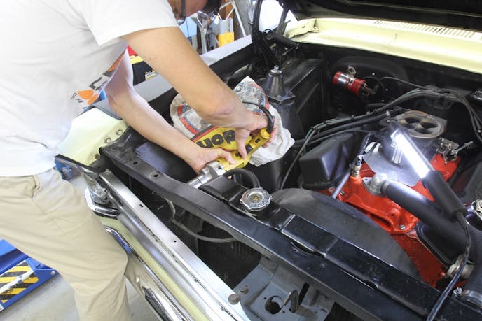 We used one of the four-inch flanges as a template and located the best positions for the holes in the radiator core support. There was just enough room to fit in our Milwaukee four-inch hole saw on our ½-inch drill motor.