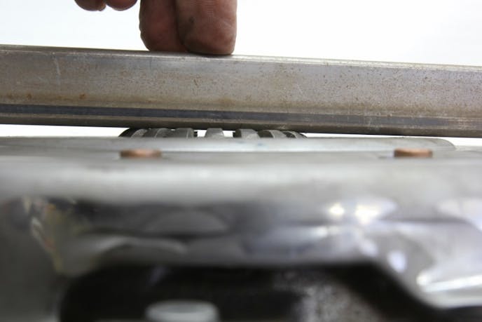 Pressure plate levers low on one side This photo reveals the pressure plate fingers are not even close to being at a consistent height when bolted down to the flywheel. This will cause horrible clutch chatter. We tried moving the clutch disc around, but this is clearly a defective pressure plate. This is why you should always perform this inspection. 