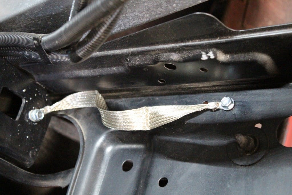 The Engine Ground strap was mounted from the bellhousing to the frame, while this body strap connects the core support to the frame. Removing the paint at the connection point is critical.
